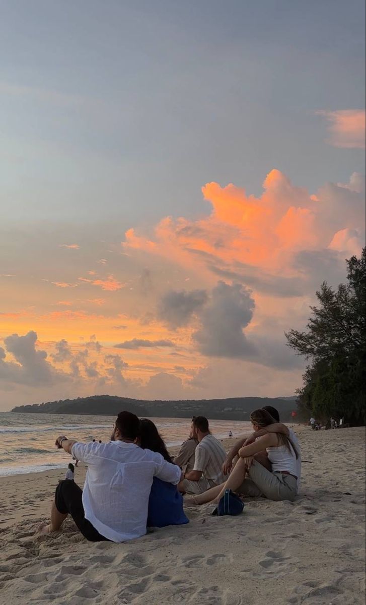 Des amis assis face au coucher du soleil